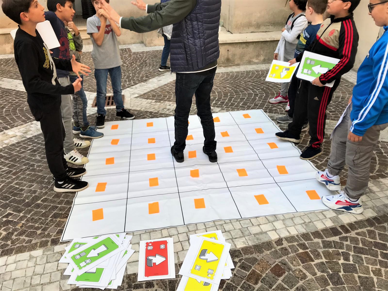 bambini che giocano con il gioco del coding unplugged e imparano termini della sostenibilità ambientale